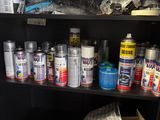 many cans of paint sitting on a shelf in a room
