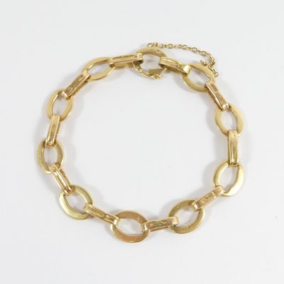 gros plan d'un bracelet en or sur fond blanc