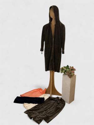a mannequin and a pair of pants next to a plant