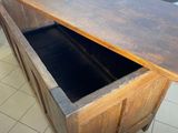 a wooden counter top with a black drawer underneath it