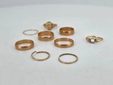 several different types of gold rings on a white surface