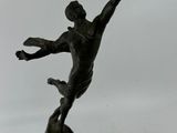 statue of a man holding a baseball bat on top of a wooden base