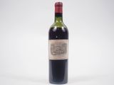 une vieille bouteille de vin posée sur une table blanche