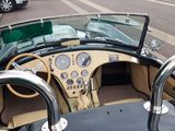 a view of a car driving down the street from the driver ' s seat