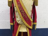 un uniforme rouge et or posé sur un présentoir pour mannequin