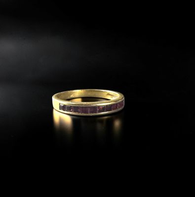 a gold ring with a purple stone in the middle