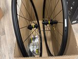 two bicycle wheels in a cardboard box on a wooden floor