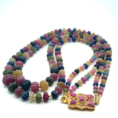 collier composé de perles multicolores et d'un pendentif doré sur fond blanc