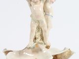 une figurine posée sur un coquillage