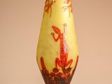 a yellow vase with a red design on it