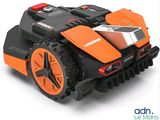 an orange and black robotic lawn mower on a white surface