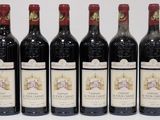 six bottles of wine are lined up on a table