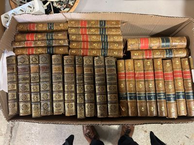 une boîte pleine de vieux livres posée sur le sol