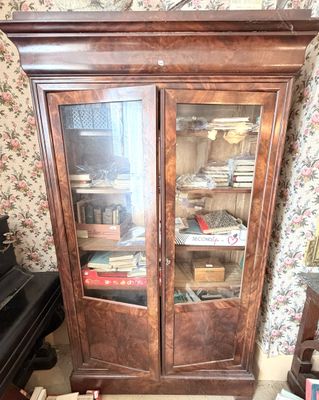 un grand meuble en bois avec des portes en verre dans une pièce