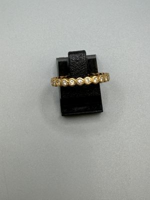 gros plan d'une bague en or avec des diamants sur une surface blanche