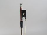 a close up of a violin bow on a wooden stand