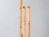a pair of bamboo flutes on a stand with a grey background