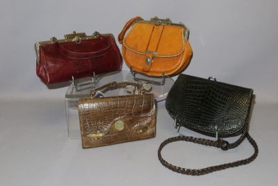 several purses are lined up on a white surface with a chain around them