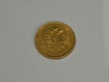 a close up of a gold coin on a white surface