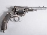 un revolver argenté posé sur une surface blanche, avec un fond blanc
