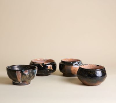 trois bols noirs et marron posés sur une table blanche