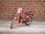 a red motorcycle parked in front of a brick wall