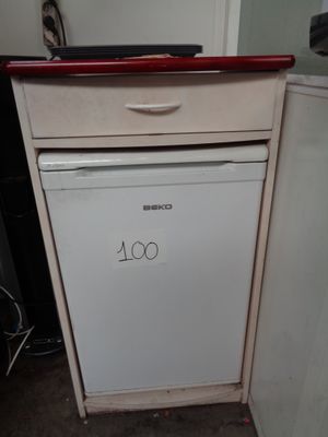 a small white dishwasher in the corner of a kitchen