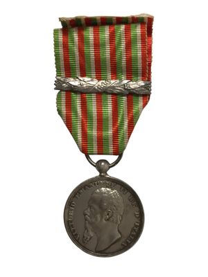 une vieille médaille entourée d'un ruban rouge, blanc et vert