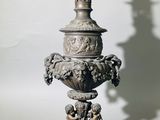 un vase en argent surmonté d'une bougie