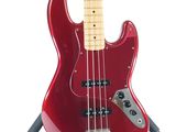 an image of a red bass guitar on a stand on a white background