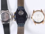 three different watches sitting next to each other on a white surface