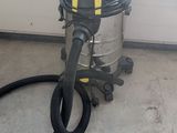 un aspirateur posé sur le sol à côté d'un tuyau
