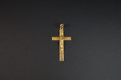 une croix dorée sur une surface noire, avec un fond noir