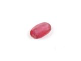 a red oval ruby stone on a white surface