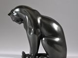 a statue of a cat that is sitting on the ground
