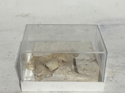 une boîte en verre contenant un peu de sable, posée sur une table