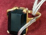 a ring with a black stone on it on a red surface