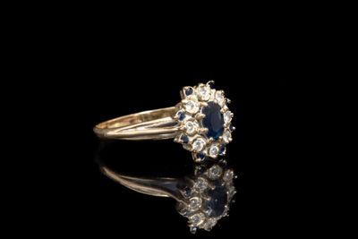 un gros plan d'une bague sertie d'un diamant et d'un saphir sur une surface noire