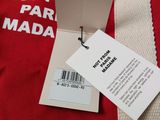 red t - shirt with a white tag on it sitting on top of a table