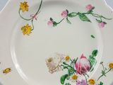 a white plate with a pink rose and yellow flowers on it