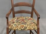 une image représentant une chaise en bois dont l'assise est recouverte d'un tissu à motifs floraux
