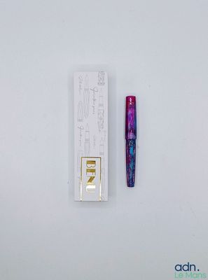 une image représentant un stylo et un étui de rouge à lèvres posés sur une surface blanche