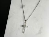 a close up of a cross on a necklace on a marble surface