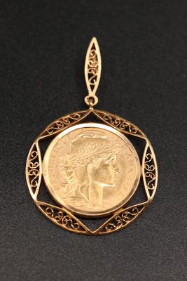 un pendentif en forme de pièce d'or, avec le visage d'une femme au centre