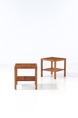 two small wooden tables sitting on top of a white surface