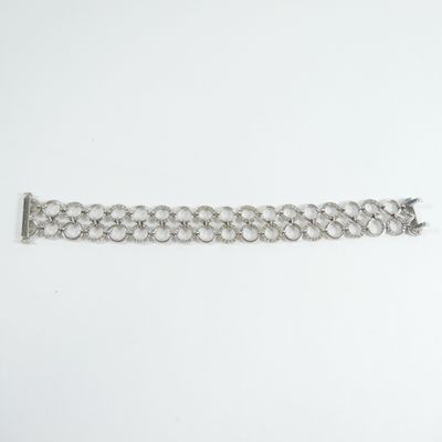 a close up of a silver chain bracelet on a white surface