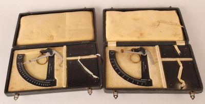 une paire d'anciens outils noirs et blancs dans un étui posé sur une surface blanche