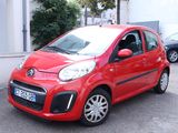 a small red car parked on the side of the road