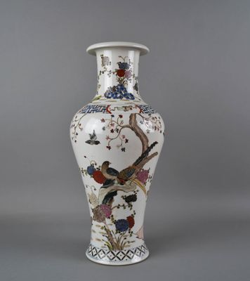 un vase blanc orné d'un oiseau et de fleurs