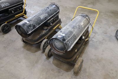 trois compresseurs d'air posés sur un chariot dans un entrepôt